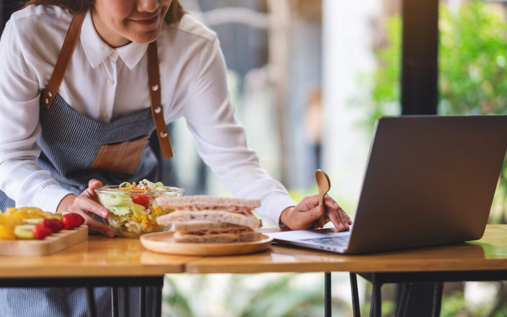 a beautiful young female videoblogger cooking in the kitchen and filming, online learning cooking class concept