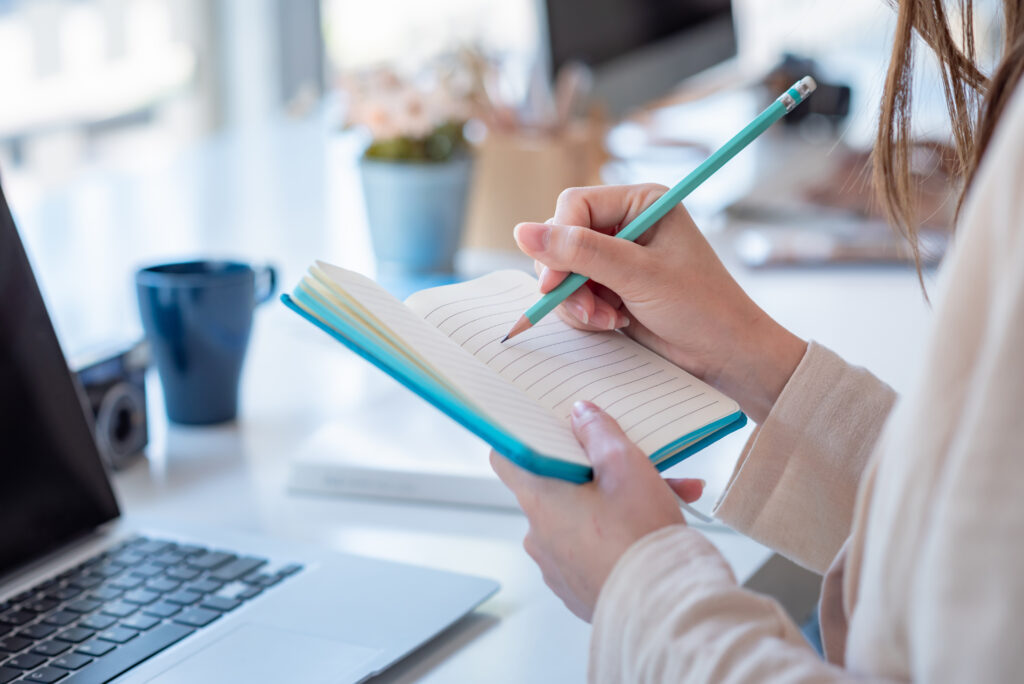 woman colleg student who taking note online learning at home.